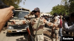 FILE - A Pakistan Ranger gestures to stop members of the media from taking pictures at an anti-terrorism court in Karachi, Pakistan, March 12, 2015. Since the military courts were reinstated in 2015, verdicts have been issued in more than 300 terrorism-related cases.