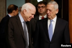 El senador John McCain (izq.), jefe de la Comisión de Servicios Armados del Senado recibe al general en retiro James Mattis para la audiencia de confirmación de Mattis como Secretario de Defensa.