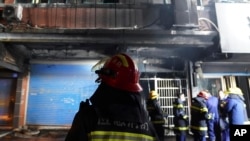 Firefighters work at the site of a building fire in Xinyu City, east China's Jiangxi Province, Jan. 24, 2024. 