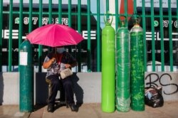 Una mujer espera delante de una planta productora de oxígeno para poder rellenar un tanque de oxígeno para familiares en medio de una escasez de oxígeno médico en Lima, Perú. San Juan de Lurigancho, febrero 21 de 2021.