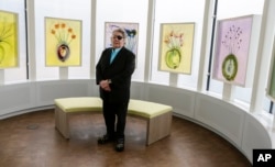 Glass artist Dale Chihuly poses for a picture in front of his "Glass on Glass" pieces in a reflection room at the Fred & Pamela Buffett Cancer Center in Omaha, Nebraska, May 19, 2017.
