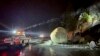 Equipos del Departamento de Transporte de California revisan grandes rocas que cayeron sobre la autopista 50, al este de Kyburz durante una tormenta en el Parque Nacional El Dorado, California, el domingo 1 de enero de 2023.
