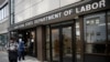 FILE - Visitors to the Department of Labor are turned away at the door by personnel due to closures over coronavirus concerns, March 18, 2020, in New York. 