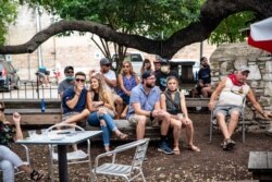 La gente se sienta en un bar al aire libre y come en medio del brote global de coronavirus (COVID-19), en Austin, Texas, EE.UU., el 28 de junio de 2020. REUTERS / Sergio Flores