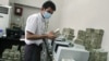 An employee counts Burmese kyat banknotes in a bank in the capital, Rangoon, April 5, 2012.