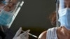 A health worker inoculates a woman with China's Sinovac COVID-19 vaccine at a temporary vaccination center in Manila, Philippines, Tuesday, June 22, 2021.