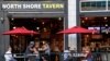 People gather at the North Shore Tavern in Pittsburgh, June 28, 2020. In response to the recent spike in COVID-19 cases, health officials are ordering all bars and restaurants in Allegheny County to stop the sale of alcohol for on-site consumption.