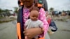 Una niña venezolana sostiene su muñeca al disponerse a embarcar en un bote en Necoclí con destino a Acandi, ambas localidades en Colombia, el 13 de octubre de 2022.