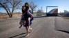 Dos migrantes adolescentes participantes de una fiesta de Quinceañera posan para los fotógrafos en el puente Rainbow de Fort Morgan, Colorado, el 16 de diciembre de 2023.