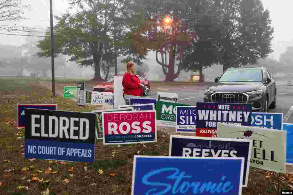 Uma mulher caminha à porta de uma assembleia de voto no dia das eleições presidenciais de 2024 nos EUA em Raleigh, Carolina do Norte, a 5 de novembro de 2024.