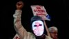 A Boeing worker wears a mask with a digital "strike" sign as employees picket after union members voted overwhelmingly to reject a contract offer and go on strike Sept. 13, 2024, outside the company's factory in Renton, Washington. 