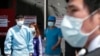 Hospital workers and visitors wearing masks pass by a precaution against the MERS, Middle East Respiratory Syndrome, virus at a quarantine tent for people who could be infected with the MERS virus at Seoul National University Hospital in Seoul, South Kore