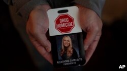 Matt Capelouto, whose daughter, Alexandra, died from a fentanyl overdose, holds an awareness card advocating for legal action against those responsible for drug-related deaths in Temecula, California, Sept. 17, 2024.