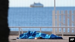 Cuerpos de víctimas cubiertos por mantas a la orilla del Mediterráneo, en Niza.