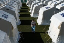 Una mujer camina en medio de las tiendas de campaña levantadas en un estadio de fútbol en Esmirna, Turquia, para residentes del terremoto del 30 de octubre. Noviembre 4 de 2020.