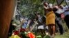 People lay flowers in honor of the dead outside the gate of the dusitD2 hotel complex which was attacked last week, at a wreath-laying event organized by the hotel complex management in Nairobi, Kenya, Jan. 22, 2019. 
