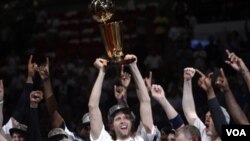 Los Mavericks de Dallas celebran su primer campeonato de la NBA, con Dirk Nowitzki, el jugador más valioso, levantando el trofeo de campeón.