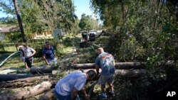 Residentes usan motosierras para despejar árboles caídos después del paso del huracán Zeta en Waveland, Mississippi, el jueves 29 de octubre de 2020.