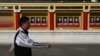 A man walks past portrait of communist party members on display outside Imperial Ancestral Temple in Beijing, China, November 12, 2012.