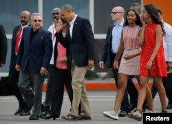 El presidente Barack Obama y sus hijas Malia y Sasha, acompañados por el presidente cubano Raúl Castro, al final de su histórica visita a la isla en 2016, caminan hacia el Air Force One.