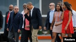 El presidente Barack Obama y sus hijas Malia and Sasha acompañados por el presidente cubano Raúl Castro caminan hacia el Air Force One, el avión del mandatario estadounidense al término de la histórica visita a Cuba de la primera familia de EE.UU.