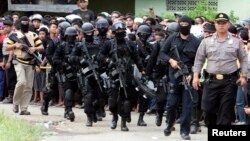 Members of the anti-terror police arrive at the village of Batu Rengat, where police exchanged fire with suspects in a house in Bandung, West Java province, May 8, 2013. 