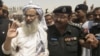 Chief cleric of the Lal Masjid or Red Mosque Abdul Aziz (L), who was caught trying to escape disguised in a woman's all-covering black burqa, arrives to attend the funeral prayers of his younger brother Abdul Rashid Ghazi in the village of Basti Abdullah,