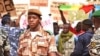 A national guard soldier walks by demonstrators at Bamako airport, Mali. (VOA - N. Palus)