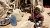 FILE - A young girl washes clothes outside her shack at the Iridimi refugee camp near Iriba in eastern Chad, Sept. 25, 2004. 