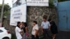 Un grupo de personas esperan fuera de la Dirección de Atención al Migrante en San Salvador, El Salvador, lugar al que llegan los salvadoreños deportados por vía terrestre, especialmente desde México. Foto AP.
