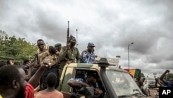 Sejumlah warga tampak menyambut rombongan pasukan keamanan yang berkonvoi di jalanan Kota Bamako, Mali, pada 19 Agustus 2020. (Foto: AP)