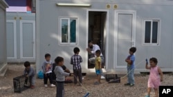 Un grupo de niños juega en el campamento de refugiados de Ritsona, a unos 86 kilómetros (53 millas) al norte de Atenas, en el Día Mundial de los Refugiados, el miércoles 20 de junio de 2018.