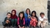 FILE - Children sit in front of a house at Deh Qubad village in Maiwand district of Kandahar province, Afghanistan, Sept. 27, 2020. 