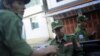 Armed soldiers from Burma's United Wa State Army shown riding a vehicle in Namteuk in neighboring China's border town of Mangka, September 3, 2009. 