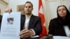 FILE - Christine Levinson (right), wife of former FBI agent Robert Levinson, watches as her son Daniel Levinson displays a web print of his father's picture to journalists while attending a news conference at Switzerland's embassy in Tehran, Dec. 22, 2007