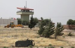 FILE PHOTO: Turkish soldiers stand on a watchtower at the Atmeh crossing on the Syrian-Turkish border, as seen from the Syrian side, in Idlib governorate, Syria, May 31, 2019.