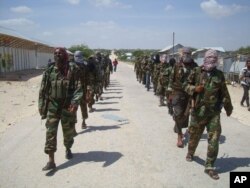 FILE - Members of Somalia's al-Shabab militant group patrol on foot on the outskirts of Mogadishu, Somalia, March 5, 2012.