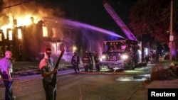 Bomberos intentan apagar un incendio en un edificio abandonado en San Luis, Missouri luego de las protestas por la muerte de un adolescente negro.