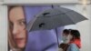 People wear masks to protect against coronavirus as they pass a shop in London, Wednesday, Feb. 3, 2021. Britain's Health Secretary Matt Hancock said Wednesday a new study suggesting that a single dose of the AstraZeneca vaccine may reduce transmission of COVID19.