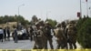  FILE - U.S. soldiers and Afghan security personnel investigate at the site of an attack in Kabul, Afghanistan, Sept. 24, 2017.