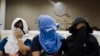 Unidentified Thai suspects of human trafficking appear at a news conference at police headquarters in Bangkok, Thailand, Aug. 4, 2015.
