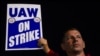 Miembros del sindicato de trabajadores automotrices UAW levantan un cartel en una huelga en una planta de Ford, en Wayne, Michigan, el 15 de septiembre de 2023.