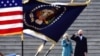 President Joe Biden salutes as his wife, Jill, puts her hand over her heart as they review the troops from the steps of the US Capitol during the inauguration, Jan. 20, 2021, in Washington. 