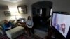 FILE - Lally Doerrer, right, and Katharine Hildebrand watch Joe Biden during his Illinois virtual town hall, in Doerrer's living room in Chicago, March 13, 2020.