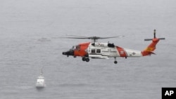 Helikopter američke Obalske straže nadleće područje u kojem se prevrnuo brod (Foto: AP/Denis Poroy)