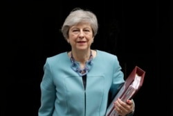 FILE - British Prime Minister Theresa May leaves 10 Downing Street in London, to attend Prime Minister's Questions at the Houses of Parliament, Wednesday, June 19, 2019.