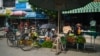 FILE - Street vendors sell vegetables on a street in Shwebo township in Sagaing region, Myanmar, Oct. 10, 2021.