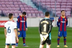Los jugadores del FC Barcelona y Osasuna guardan un minuto de silencio en memoria de Diego Armando Maradona antes del inicio del partido de fútbol de la Liga española en el estadio Camp Nou de Barcelona, España, el domingo 29 de noviembre de 2020.