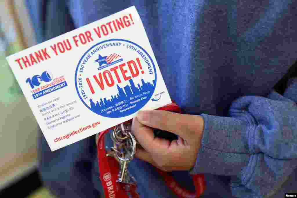 Una persona sostiene una pegatina en un colegio electoral en Deja Hue Art el día de las elecciones en Chicago, Illinois.