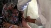 FILE - A woman receives a COVID-19 vaccine on July 11, 2021, in Kabul, Afghanistan. The dose was donated by the United States and delivered through the COVAX program.
